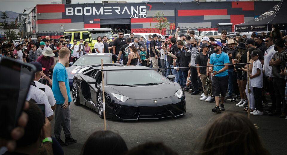 A black Lamborghini drawing a crowd at a car show