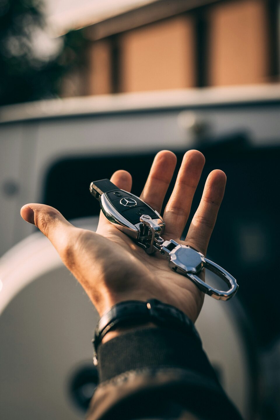A hand holding out a car key