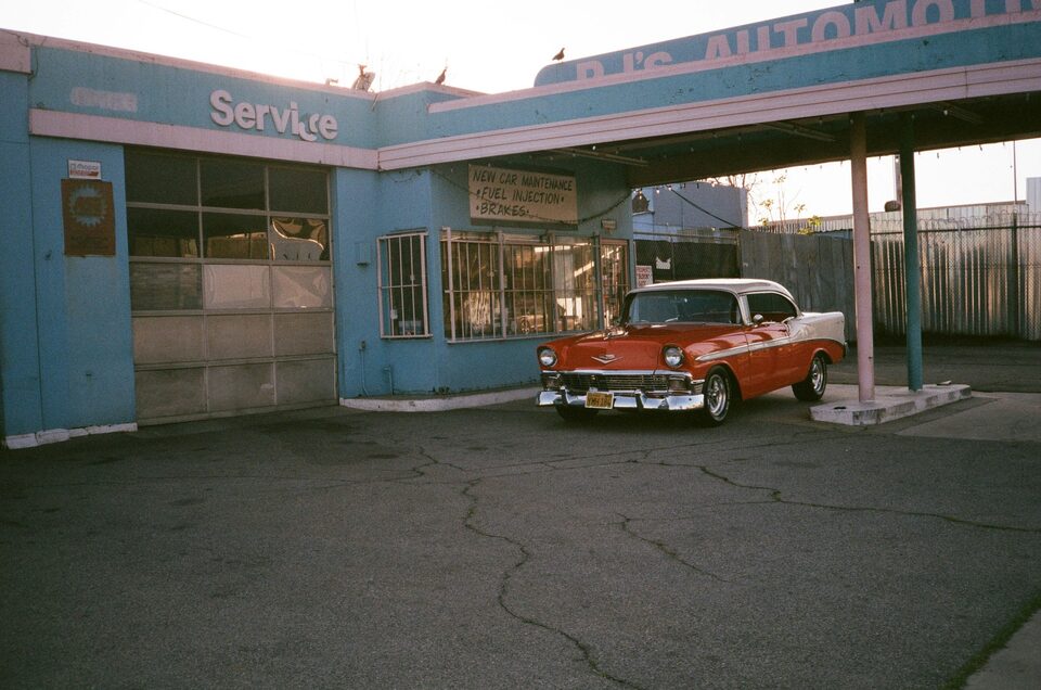 A red and white classic Chevrolet at a vintage service station