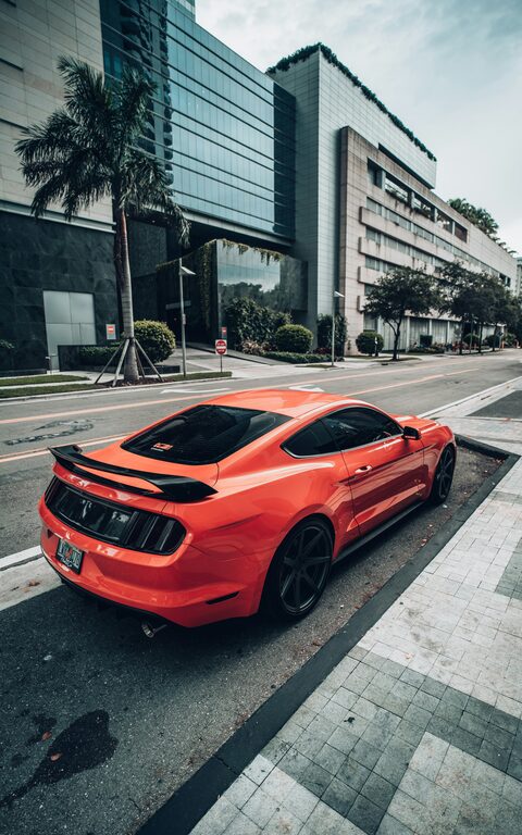 An orange Ford Mustang on a city street