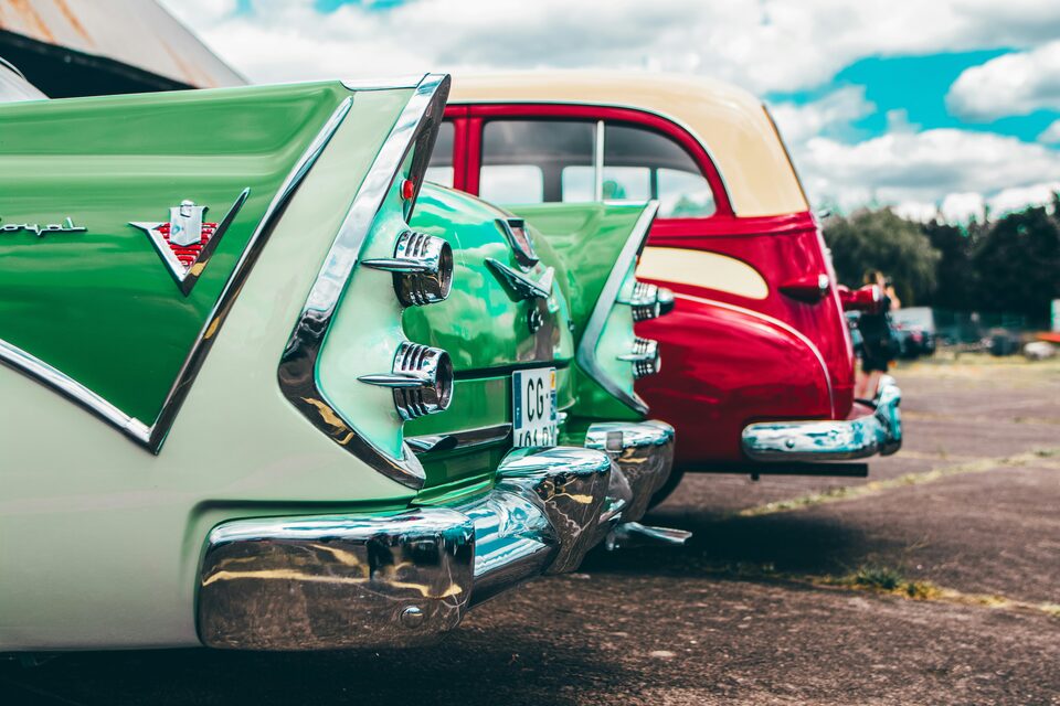 The fins of green and red classic cars at a show