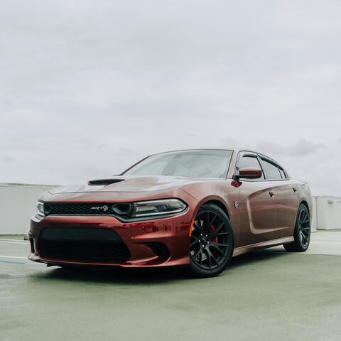 A copper Dodge Charger parked by the water