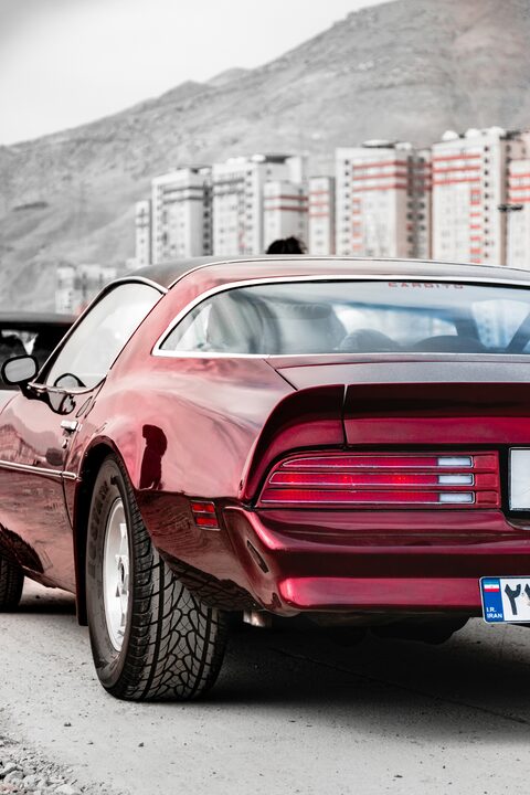 The rear of a red classic Pontiac Firebird