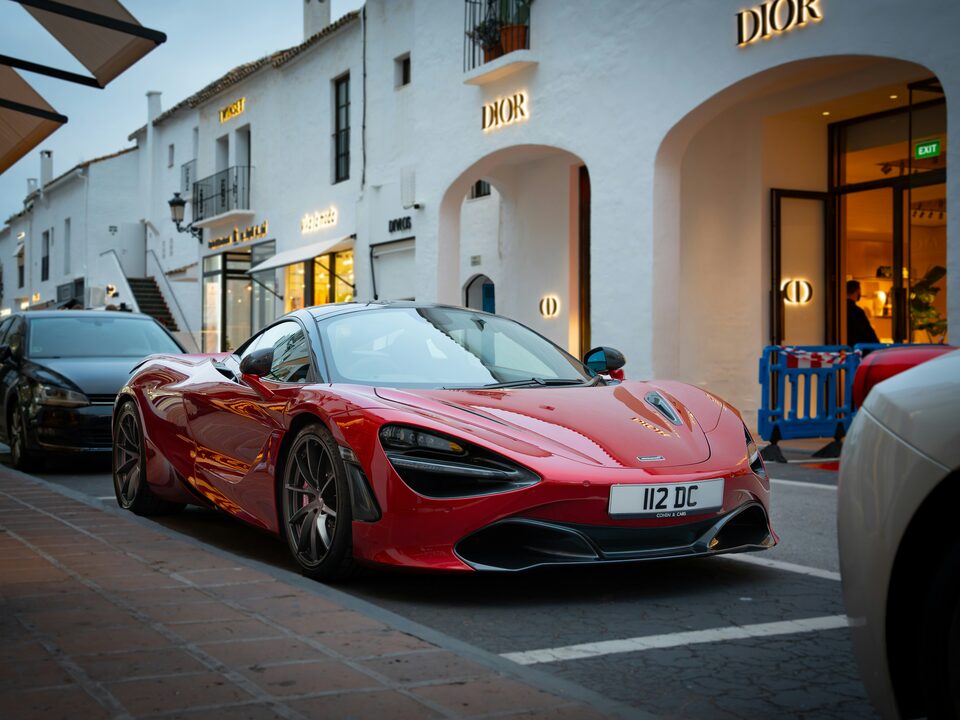 A red McLaren parked on a sunny street
