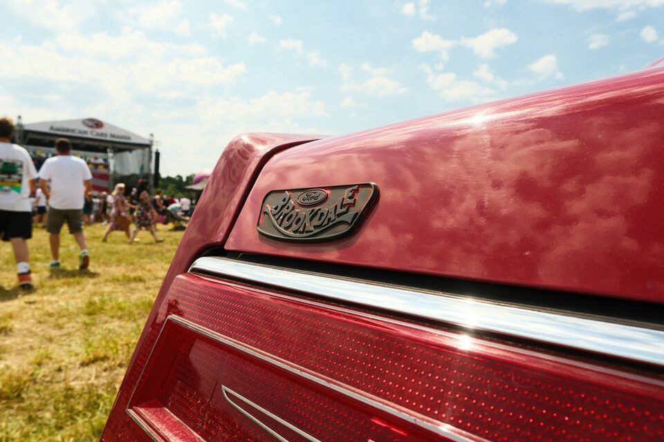 The fender badge of a red classic car at a show