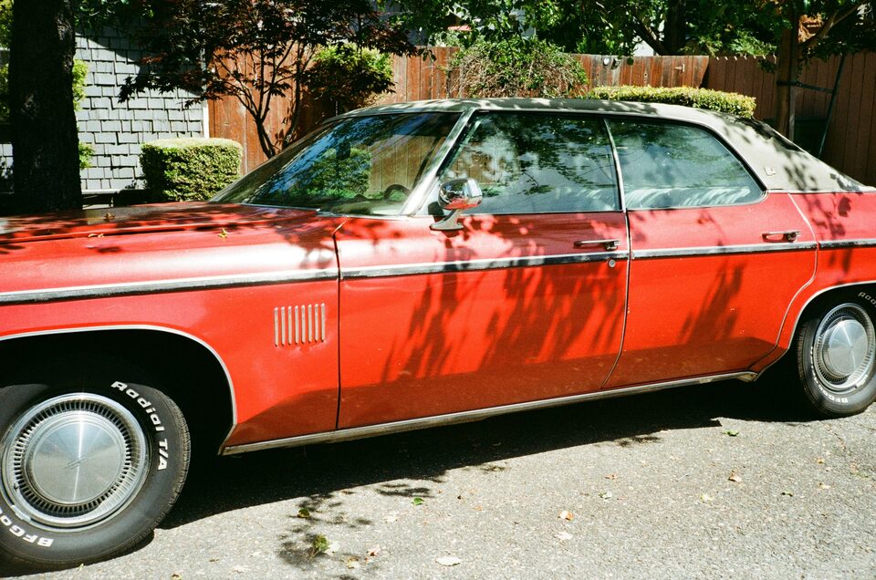 A red classic Ford parked on the grass