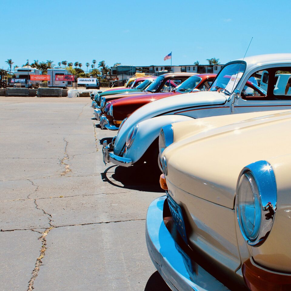 A row of classic cars lined up on a sunny lot