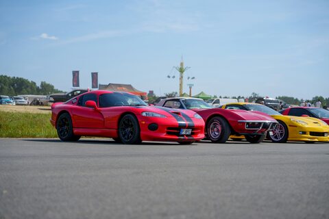 A row of red and yellow sports cars at a car event