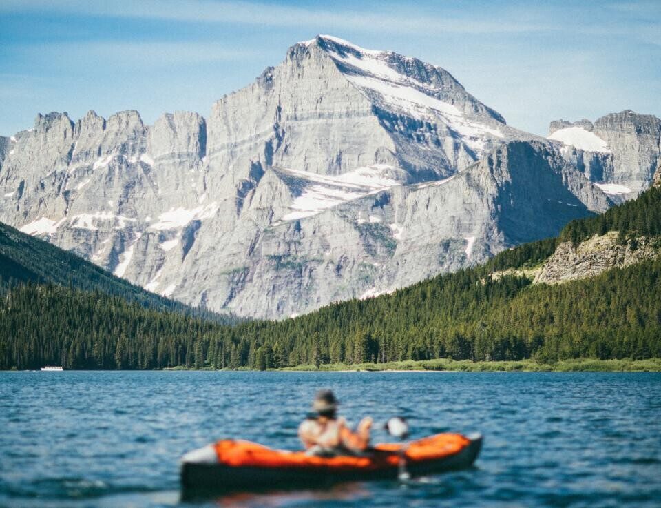 Snowy mountains rising above a forest lake