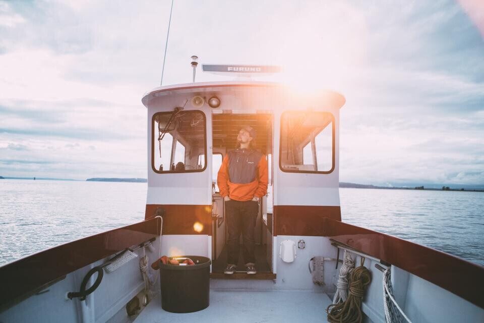The bow of a fishing boat heading out at sunrise