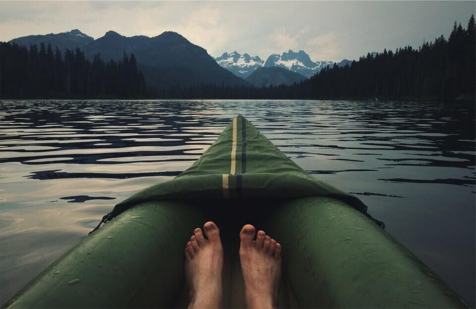 The bow of a kayak on a mountain lake