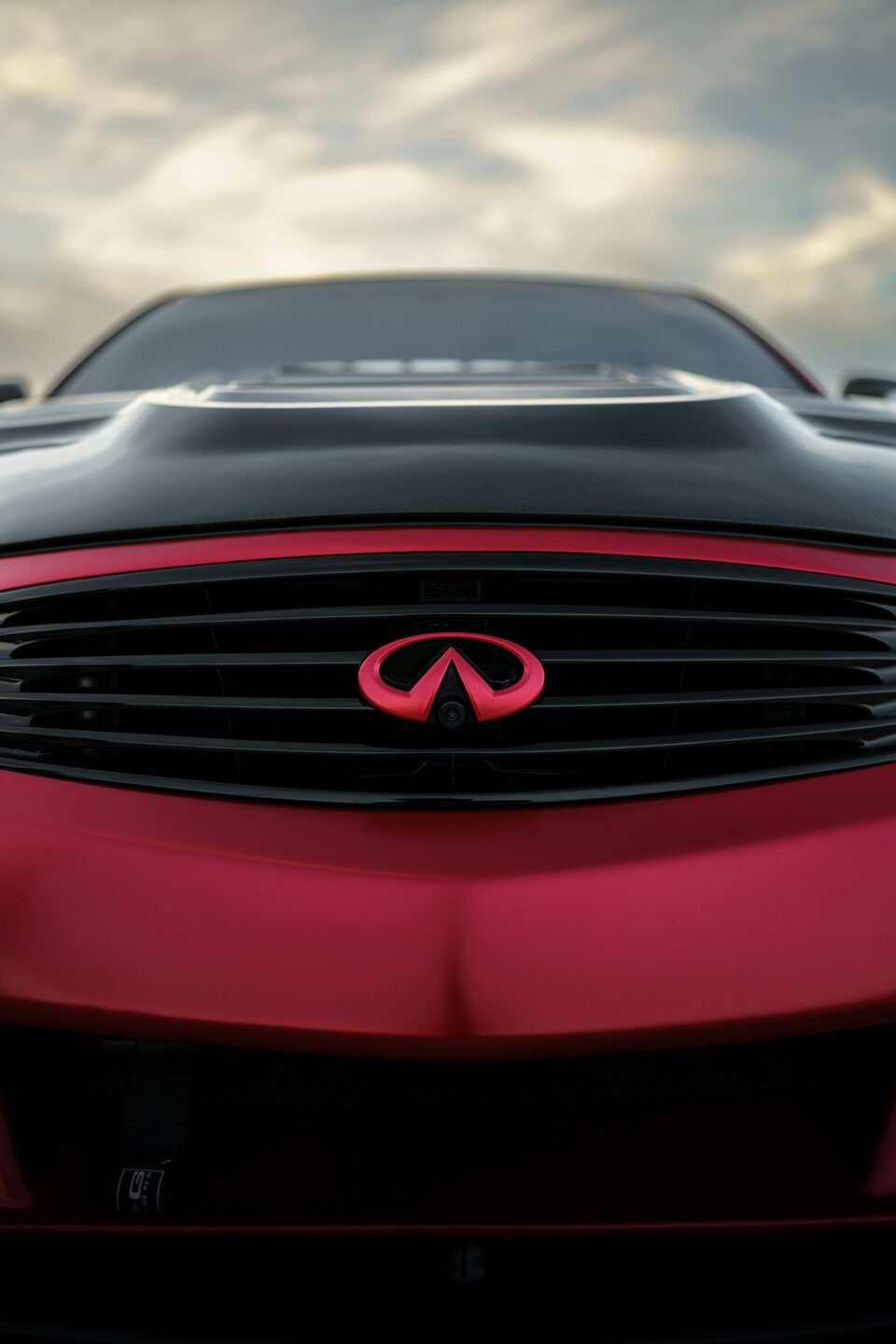 The grille and badge of a red Infiniti
