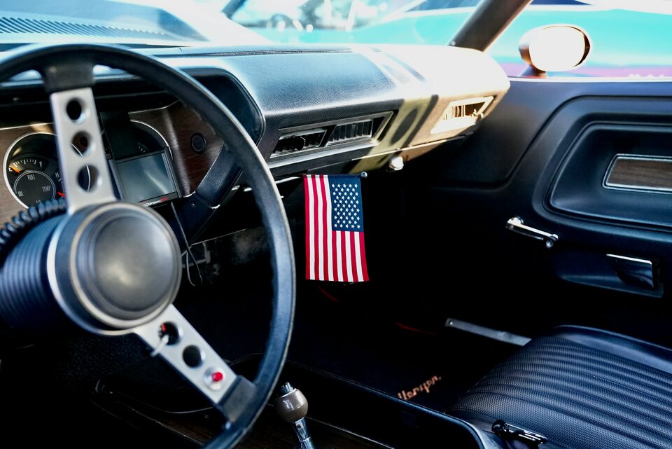 The interior of a classic car, looking across the steering wheel