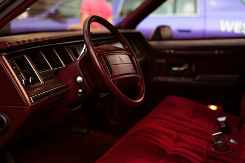 The red interior and steering wheel of a classic car