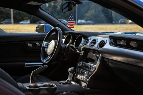 A car interior with a small American flag on the dash