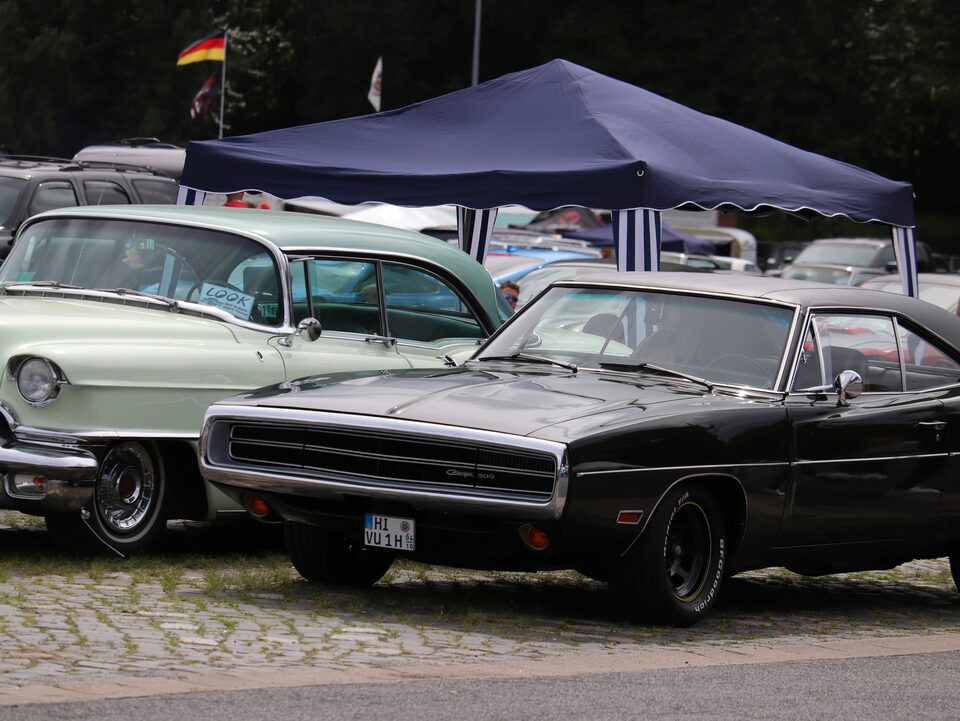 Classic cars under a canopy at an outdoor show