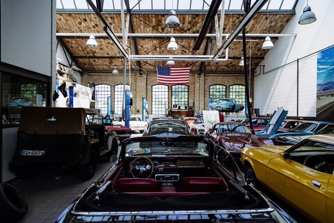 Vintage cars lined up inside a showroom