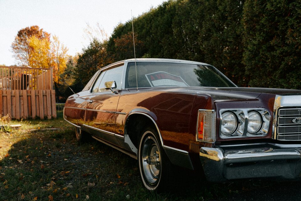 A brown classic Lincoln parked on the grass