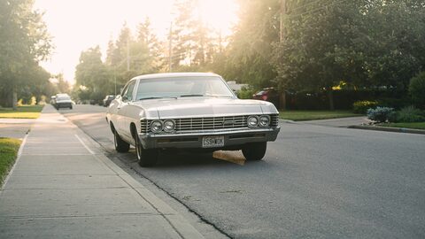 A classic sedan on a sunlit suburban street
