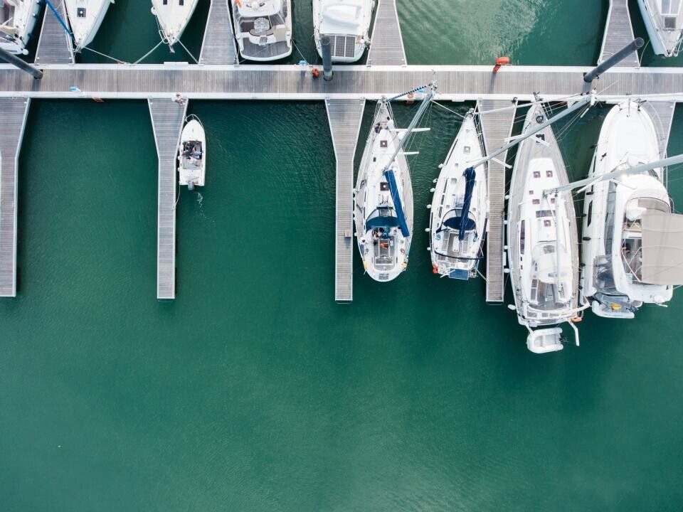 White motorboats docked in green water from above