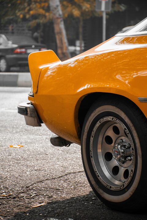 The wheel of an orange classic car